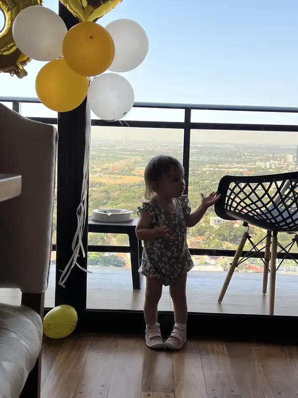 Una niña junto a los globos de la celebración